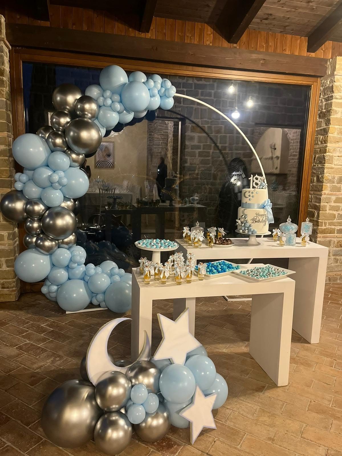 Allestimento per un diciottesimo con palloncini, torta e confettata